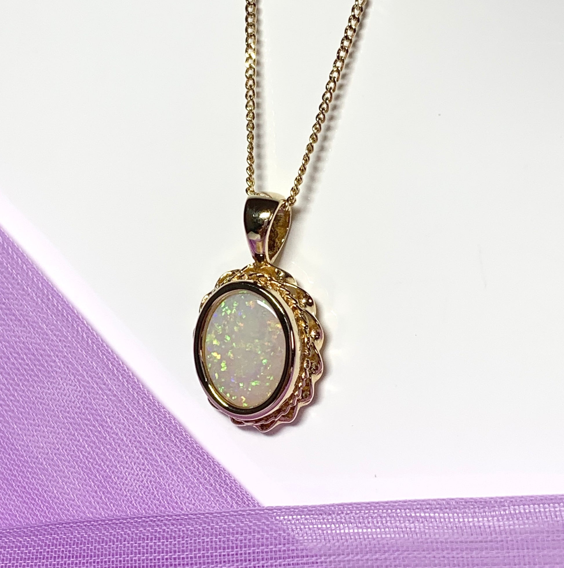 Oval real opal yellow gold necklace with a roped edge