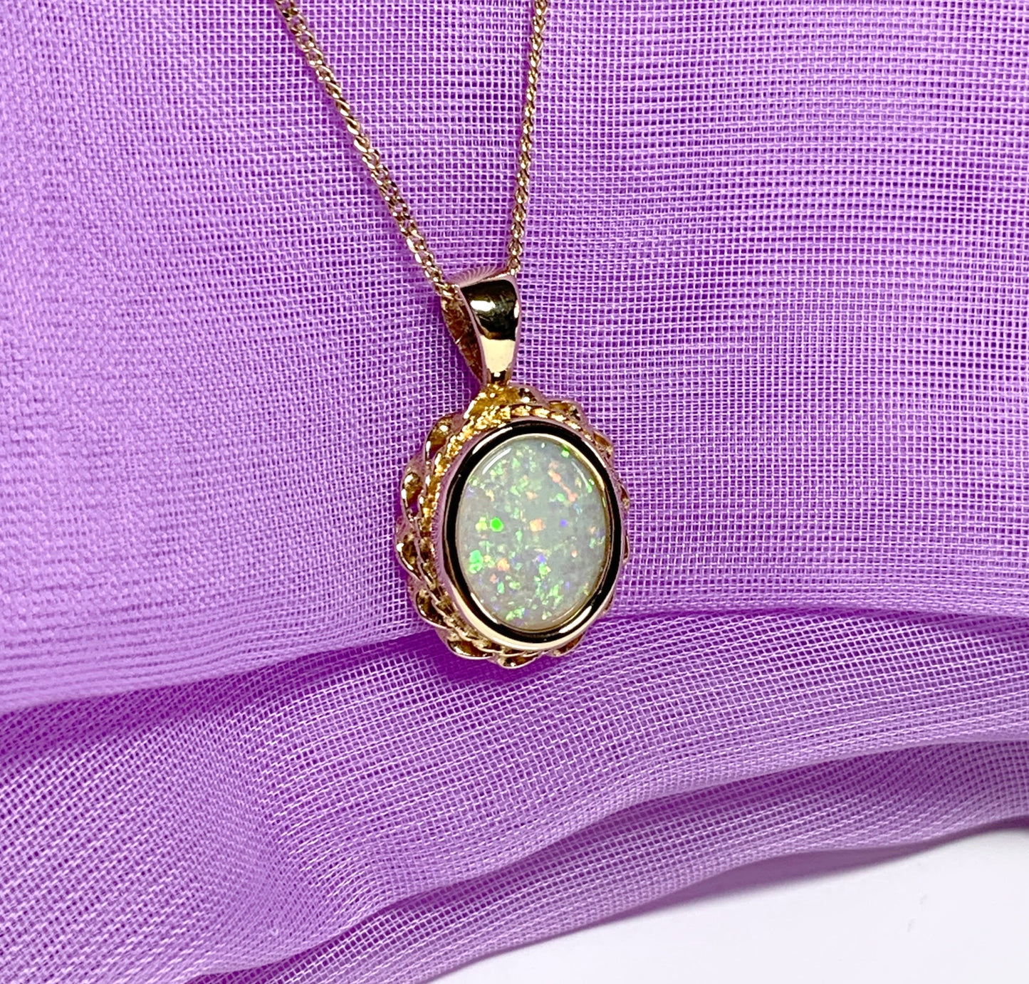 Oval real opal yellow gold necklace with a roped edge