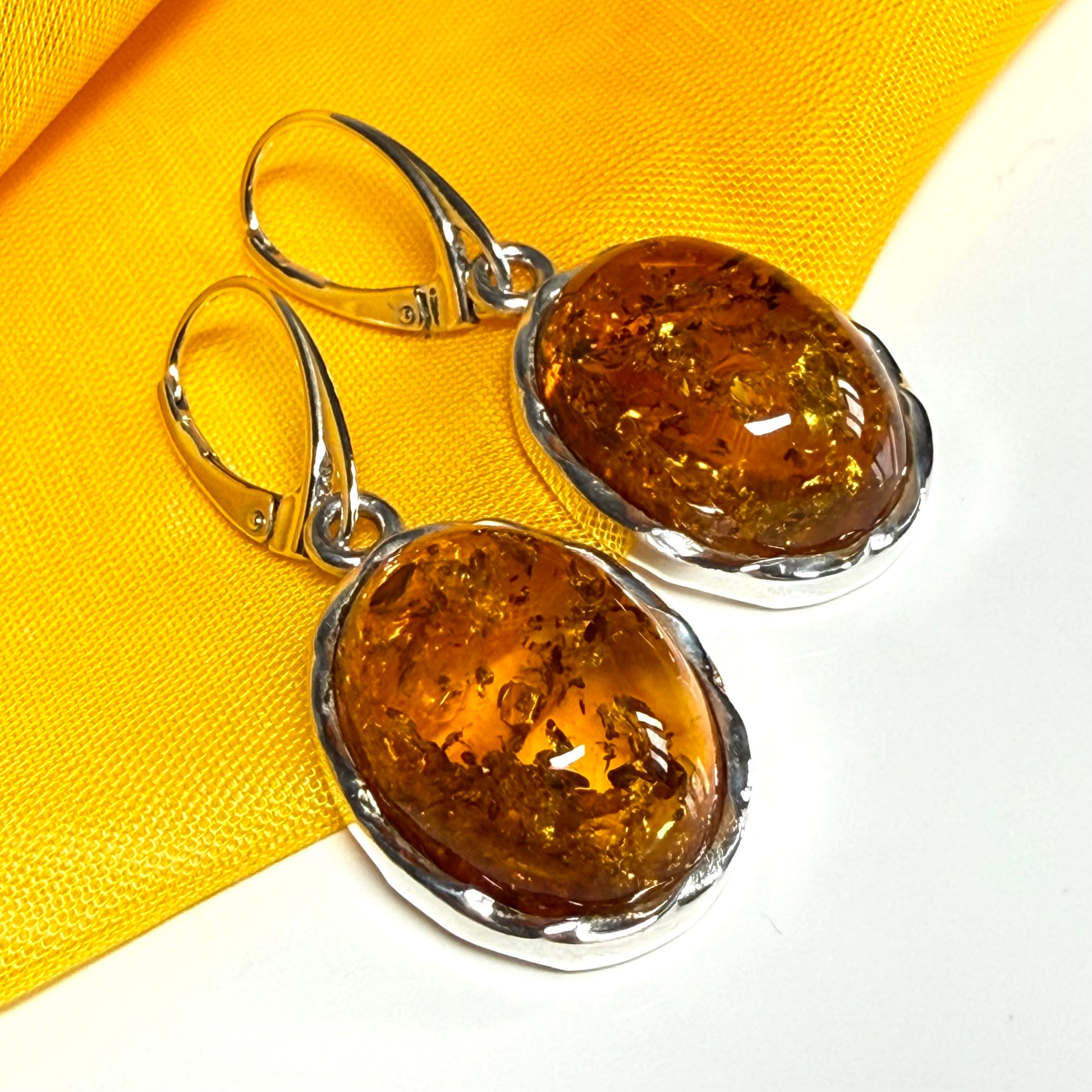 A pair of real amber drop earrings oval in shape sterling silver continental wire fittings