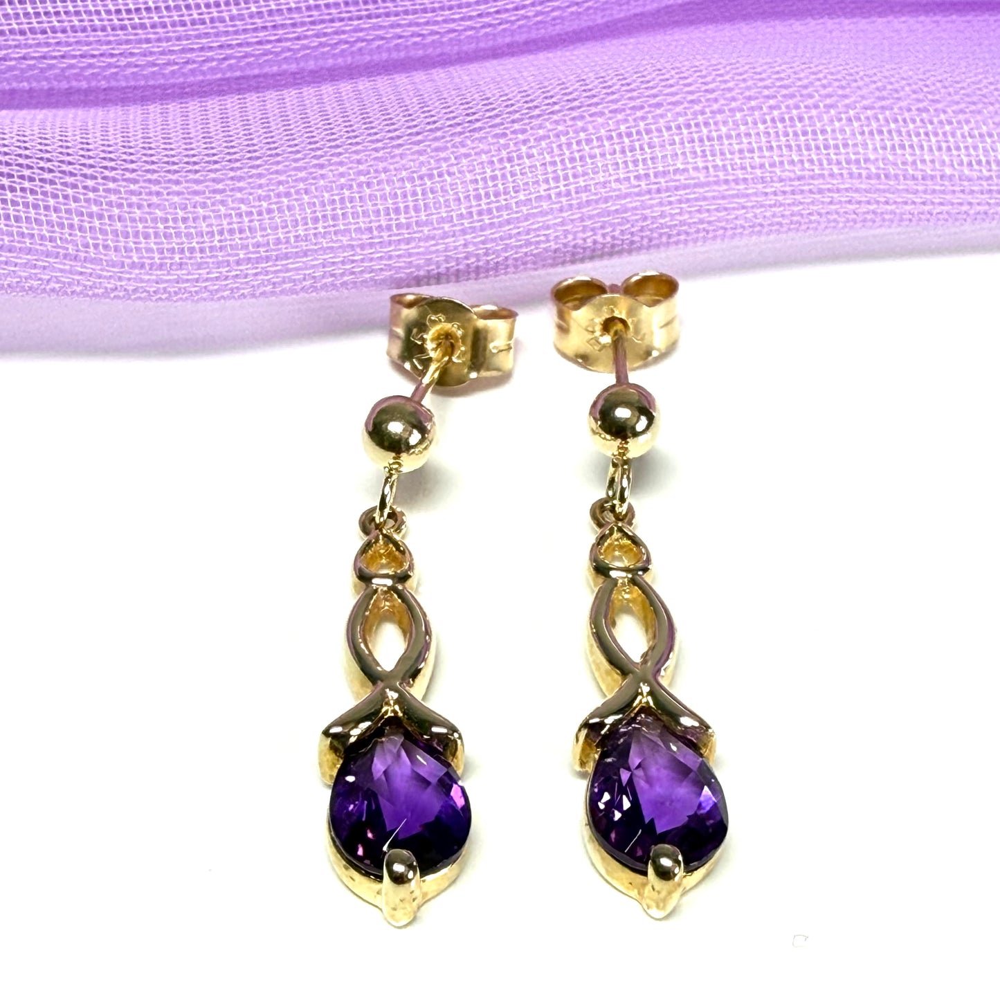 A pair of real amethyst drop earrings pear shaped yellow gold