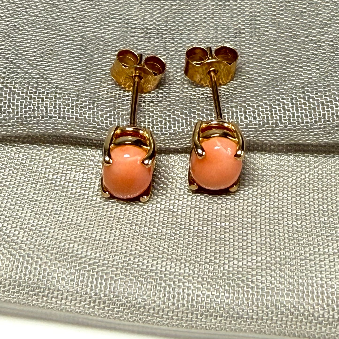 A pair of real coral oval shaped stud earrings yellow gold