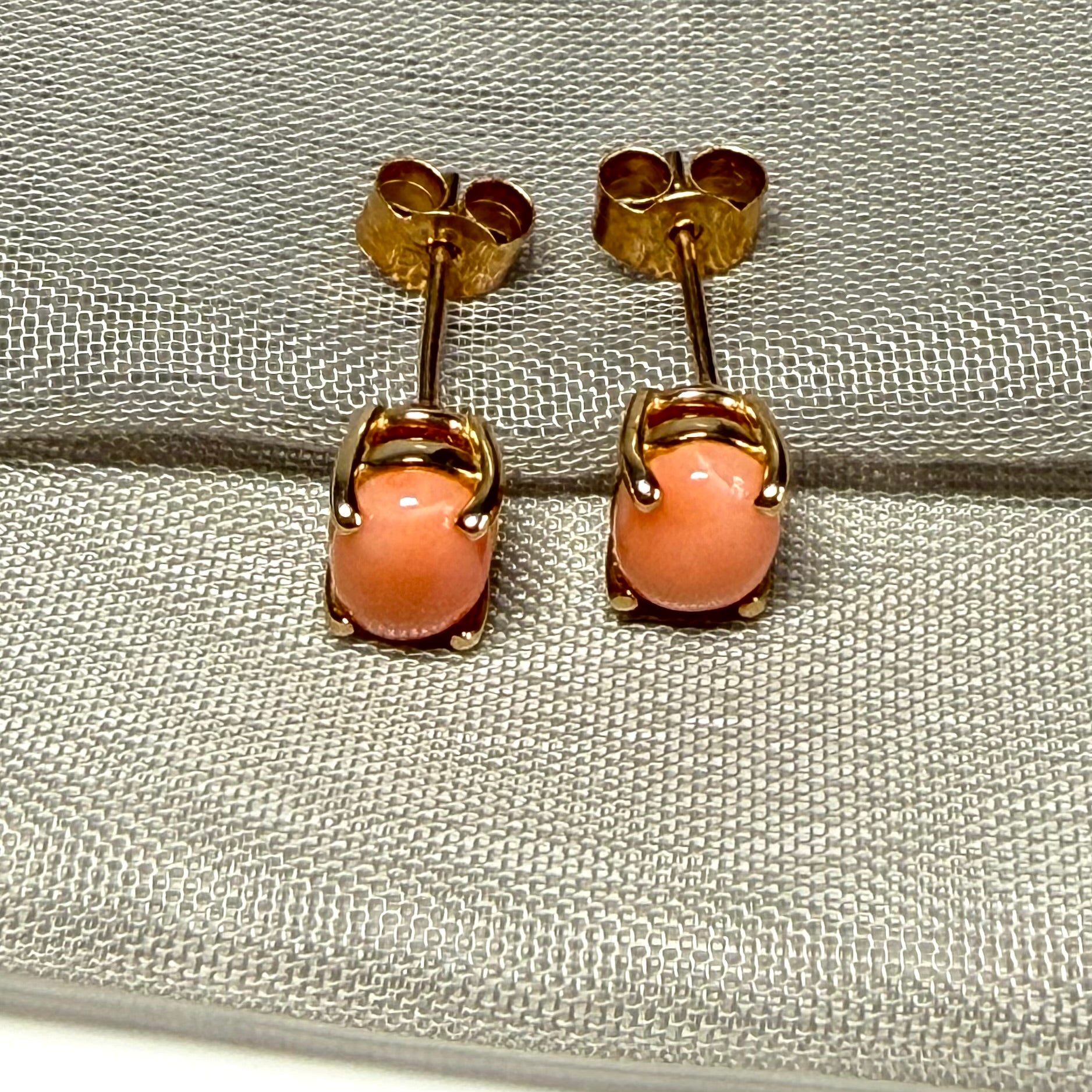 A pair of real coral oval shaped stud earrings yellow gold