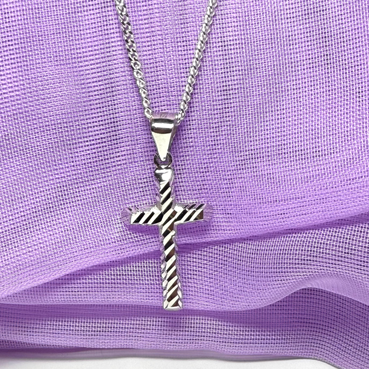 Diamond cut cross patterned sterling silver with a chain Included