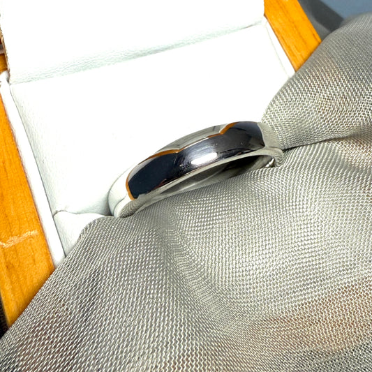 Silver ring with blue inlay on a textured surface