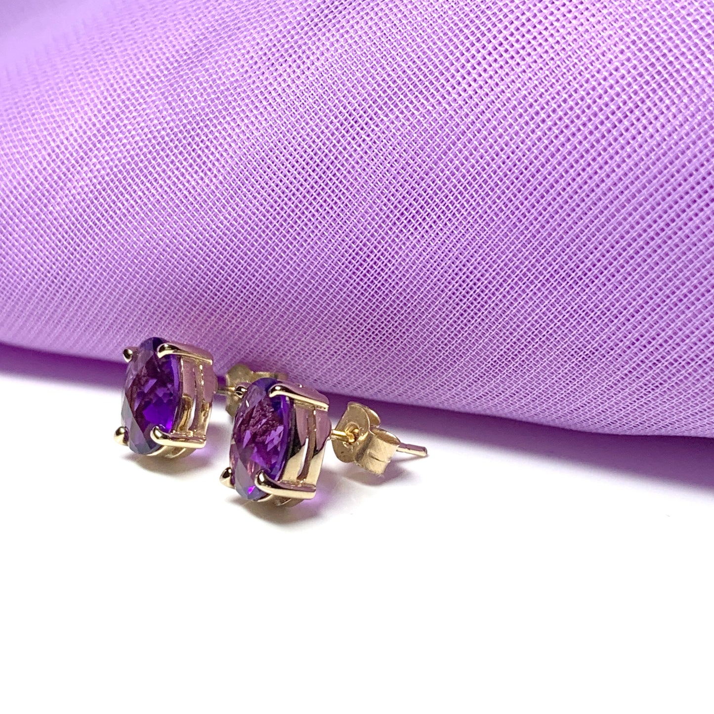 Purple oval amethyst stud earrings in yellow gold