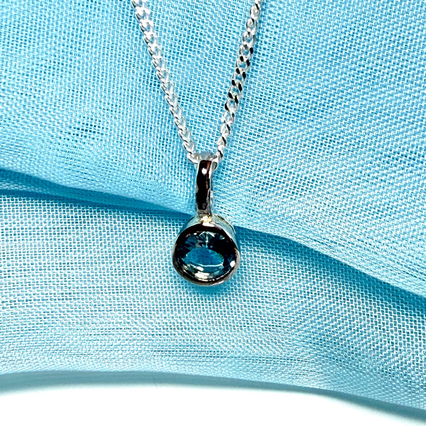 Real blue topaz round sterling silver necklace with a smooth rubbed over pendant