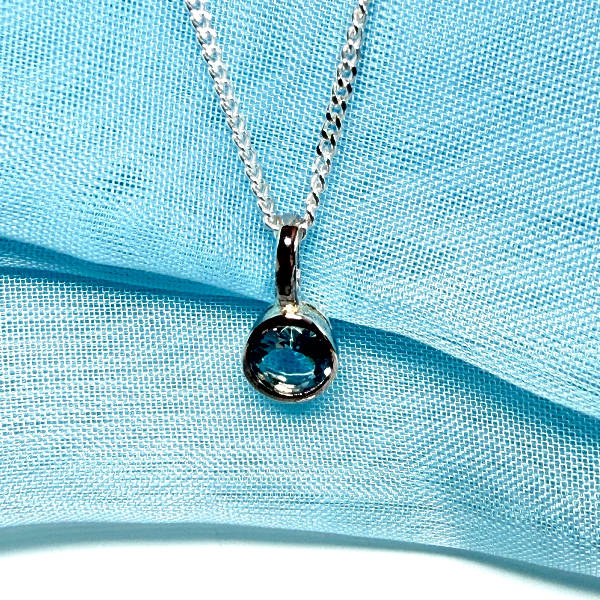 Real blue topaz round sterling silver necklace with a smooth rubbed over pendant