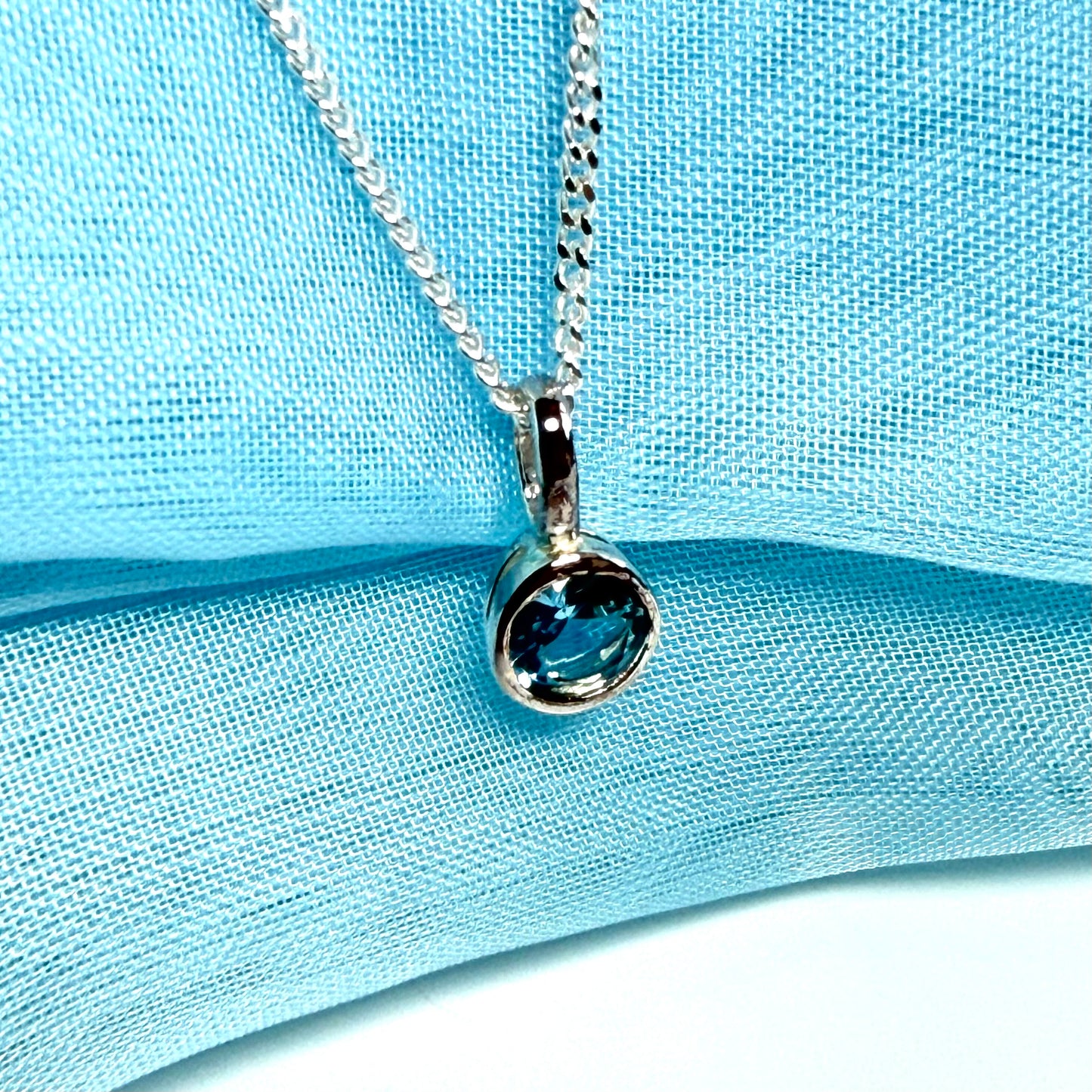 Real blue topaz round sterling silver necklace with a smooth rubbed over pendant