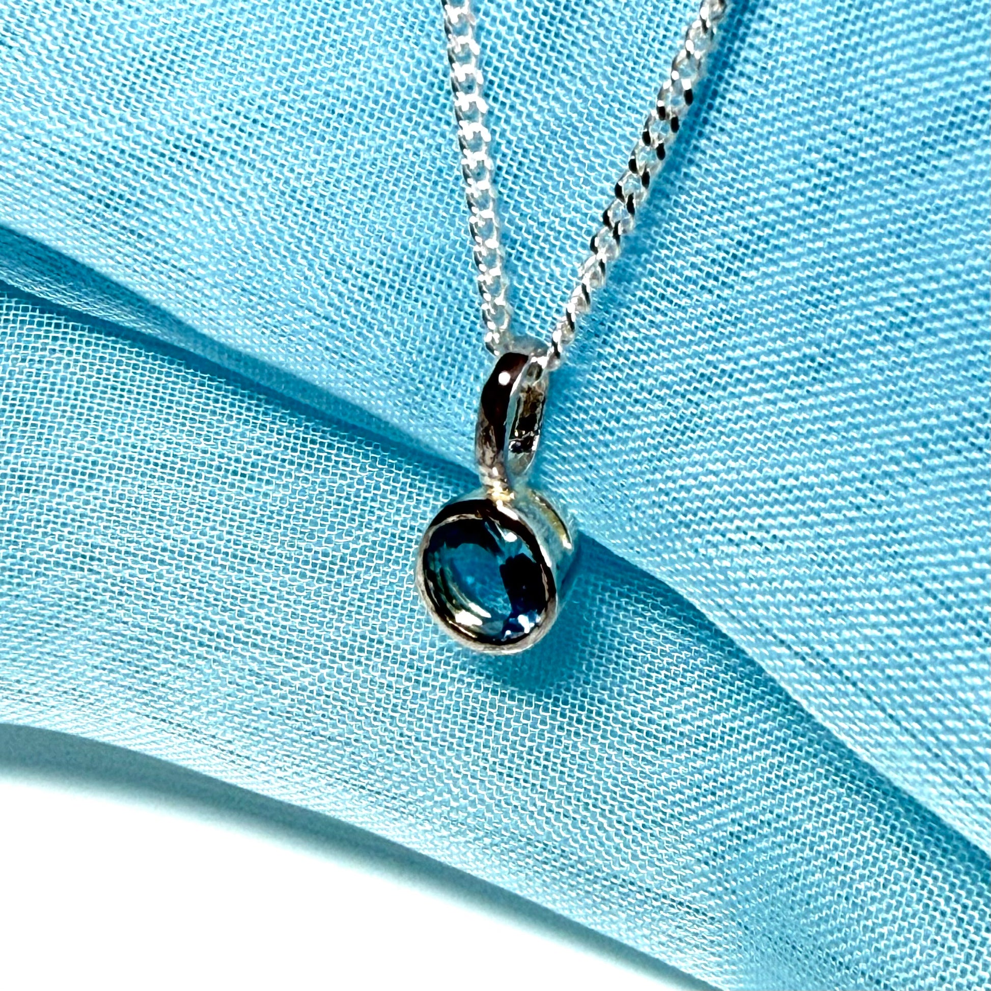Real blue topaz round sterling silver necklace with a smooth rubbed over pendant