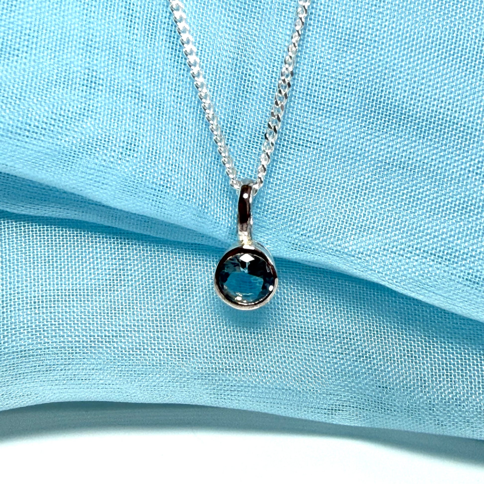 Real blue topaz round sterling silver necklace with a smooth rubbed over pendant
