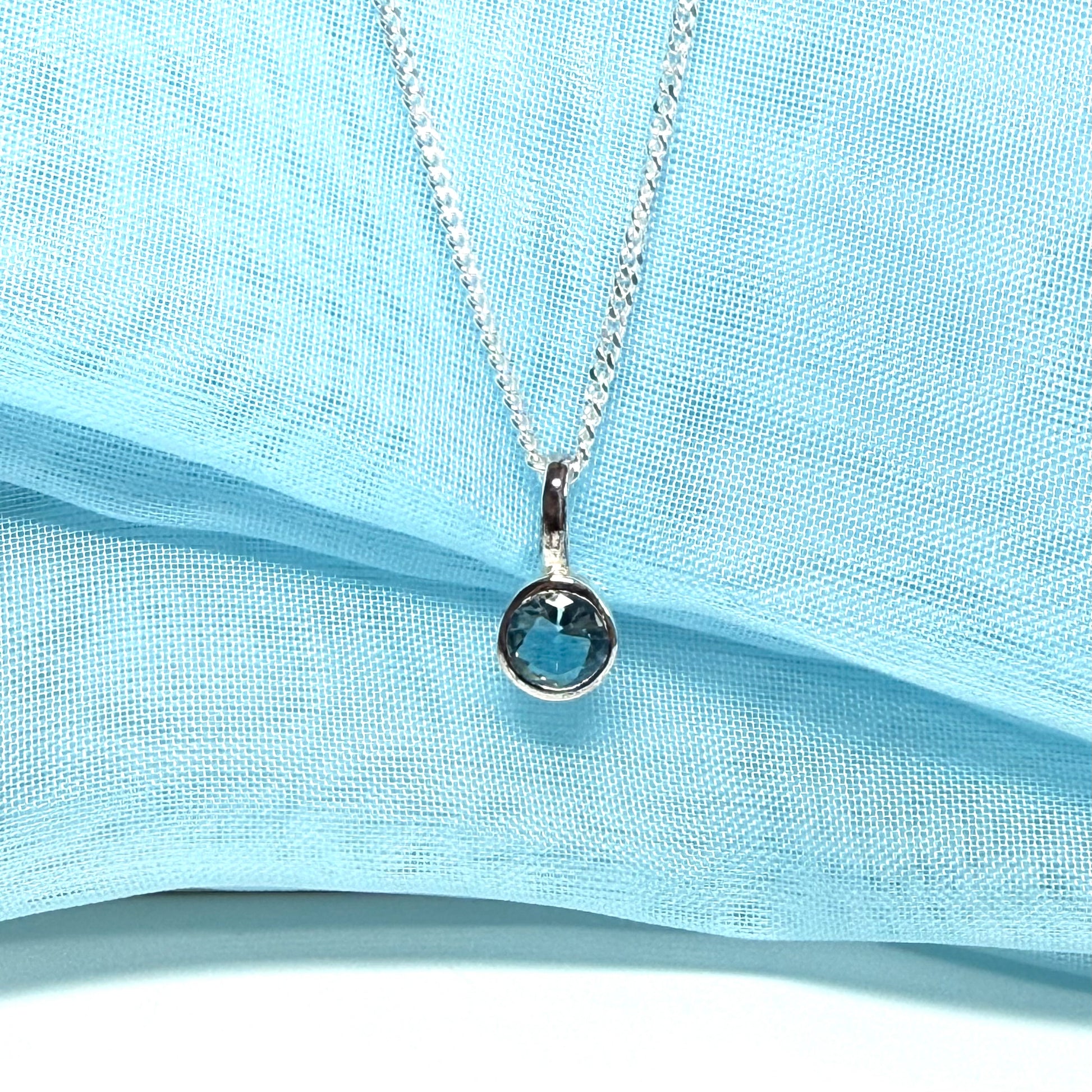 Real blue topaz round sterling silver necklace with a smooth rubbed over pendant