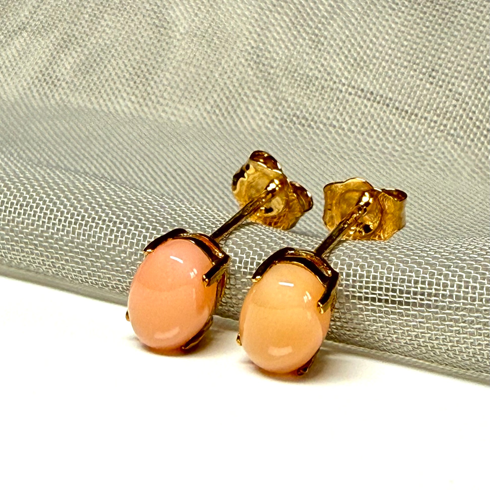 Real coral oval stud earrings yellow gold within a simple four claw setting