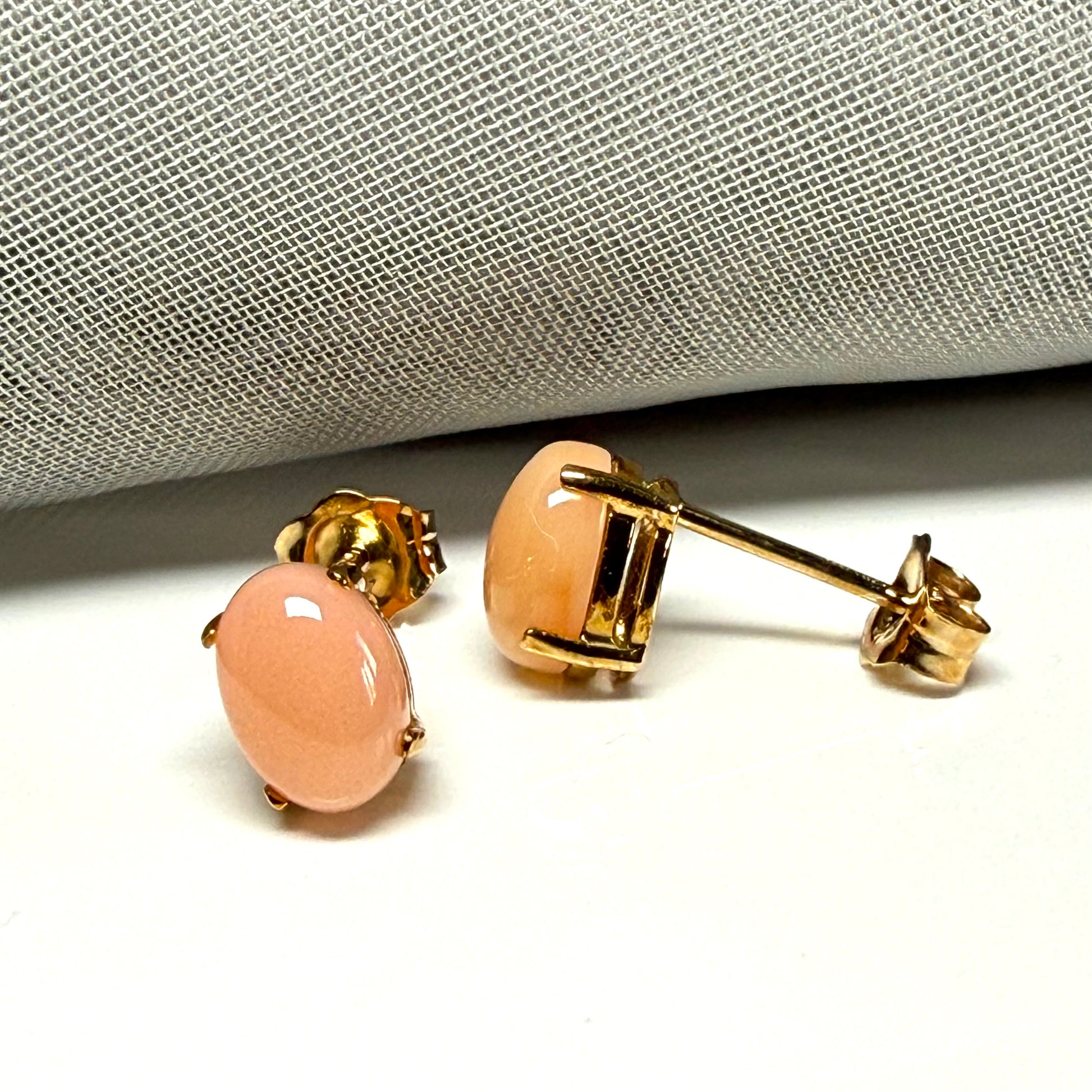 Real coral oval stud earrings yellow gold within a simple four claw setting