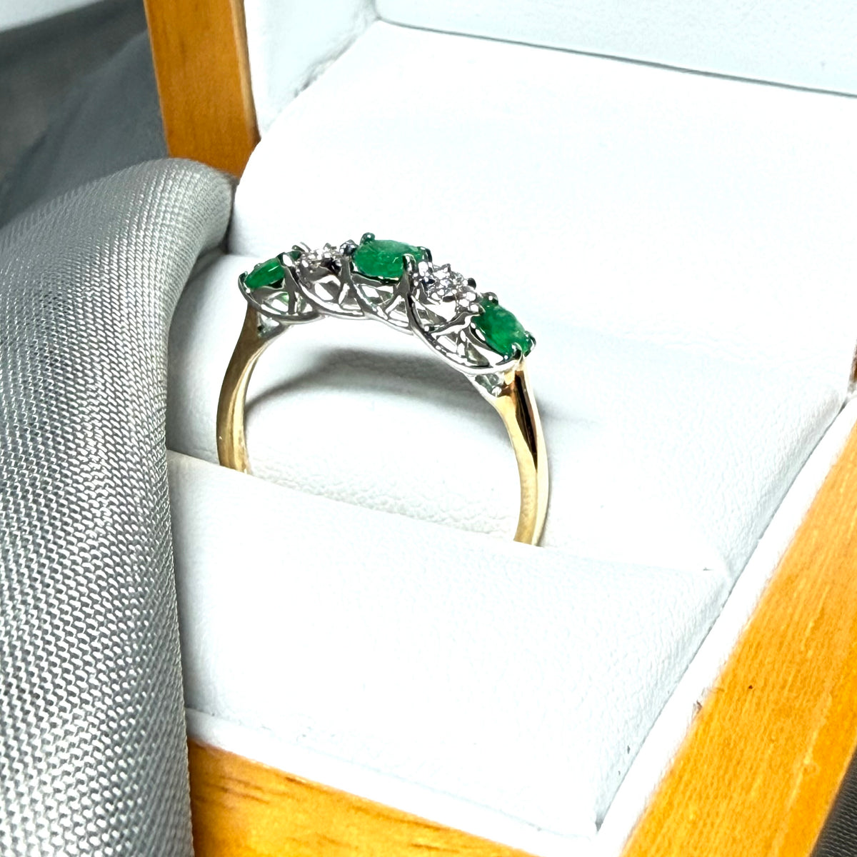 Real emerald and diamond yellow gold eternity ring claw setting