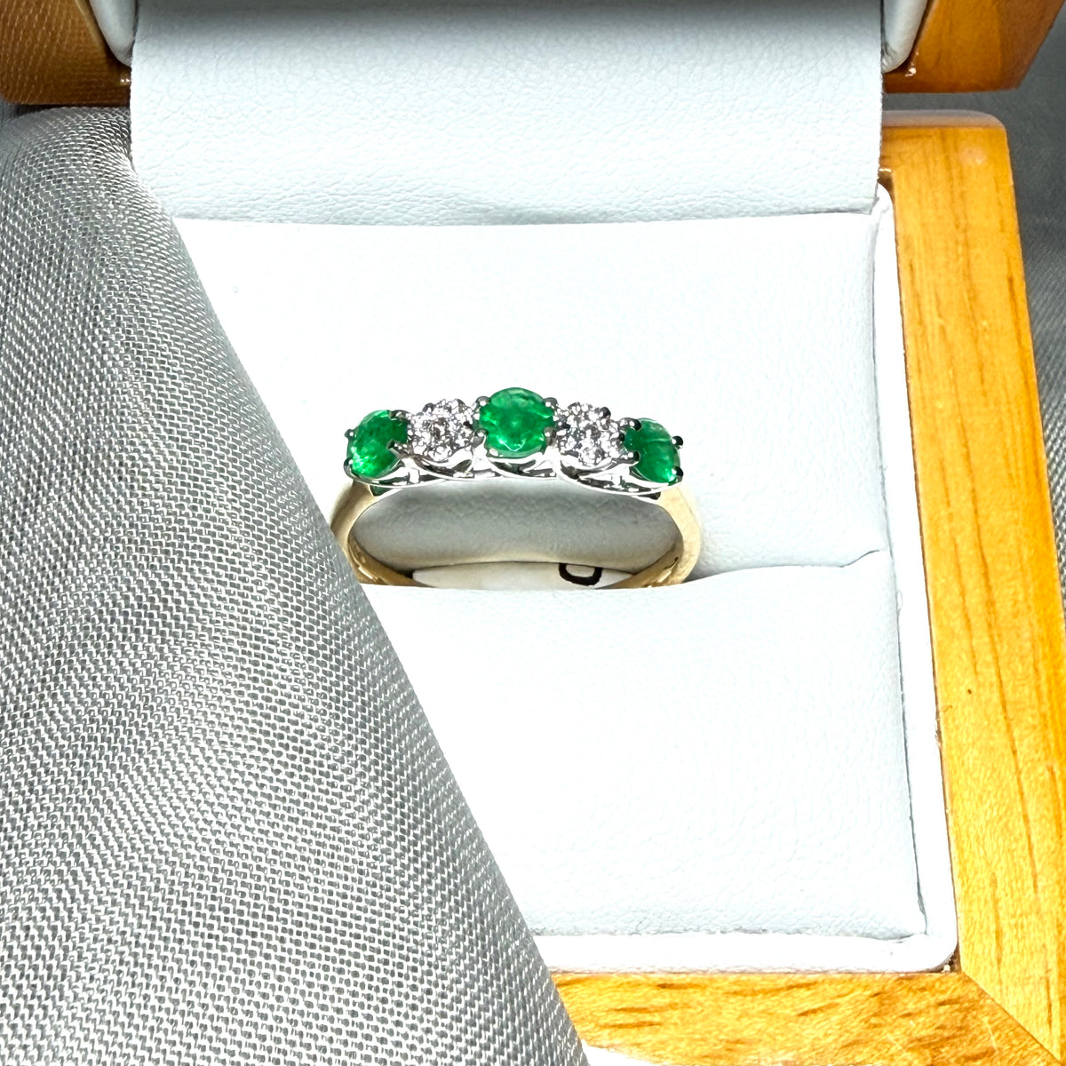 Real emerald and diamond yellow gold eternity ring claw setting