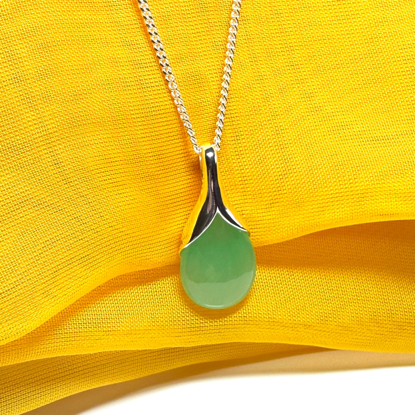 A real green jade necklace in a teardrop or pear shaped including a chain and a gift box included
