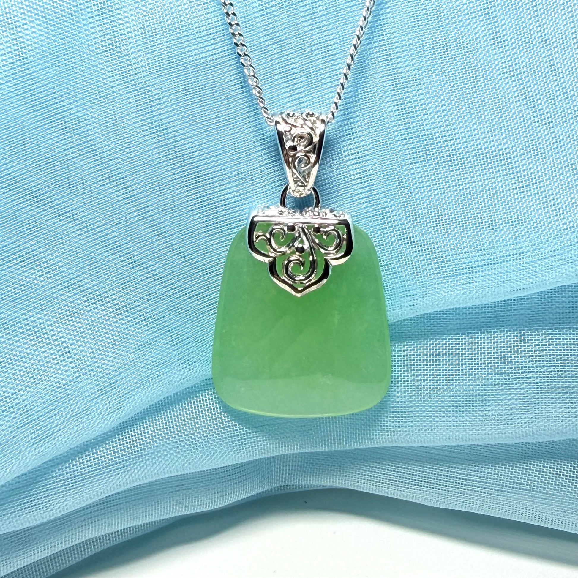 Real green jade necklace with a large shaped and patterned top pendant