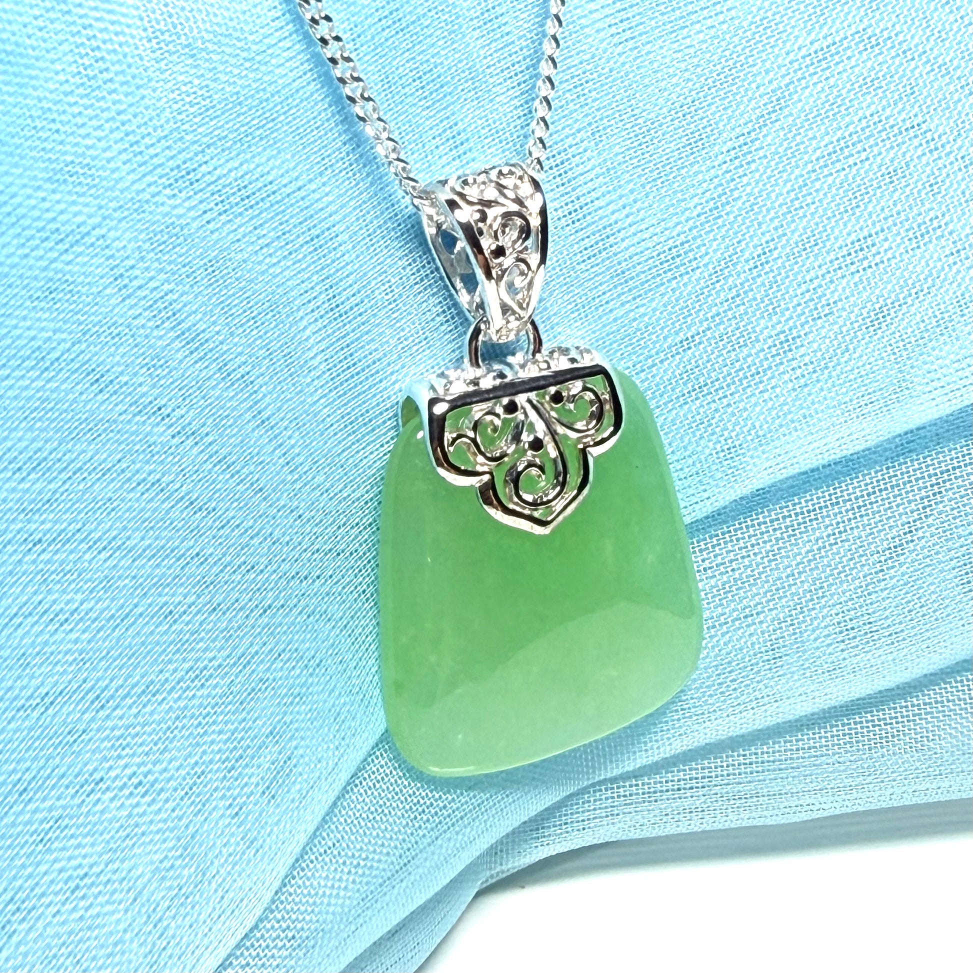 Real green jade necklace with a large shaped and patterned top pendant
