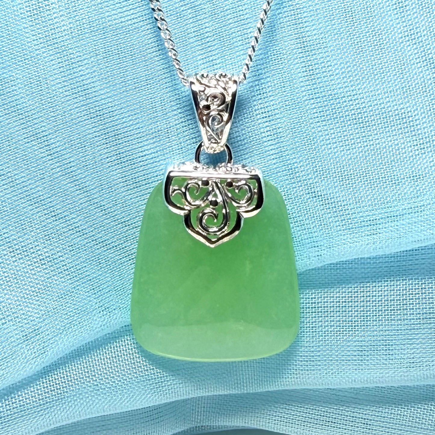 Real green jade necklace with a large shaped and patterned top pendant with chain