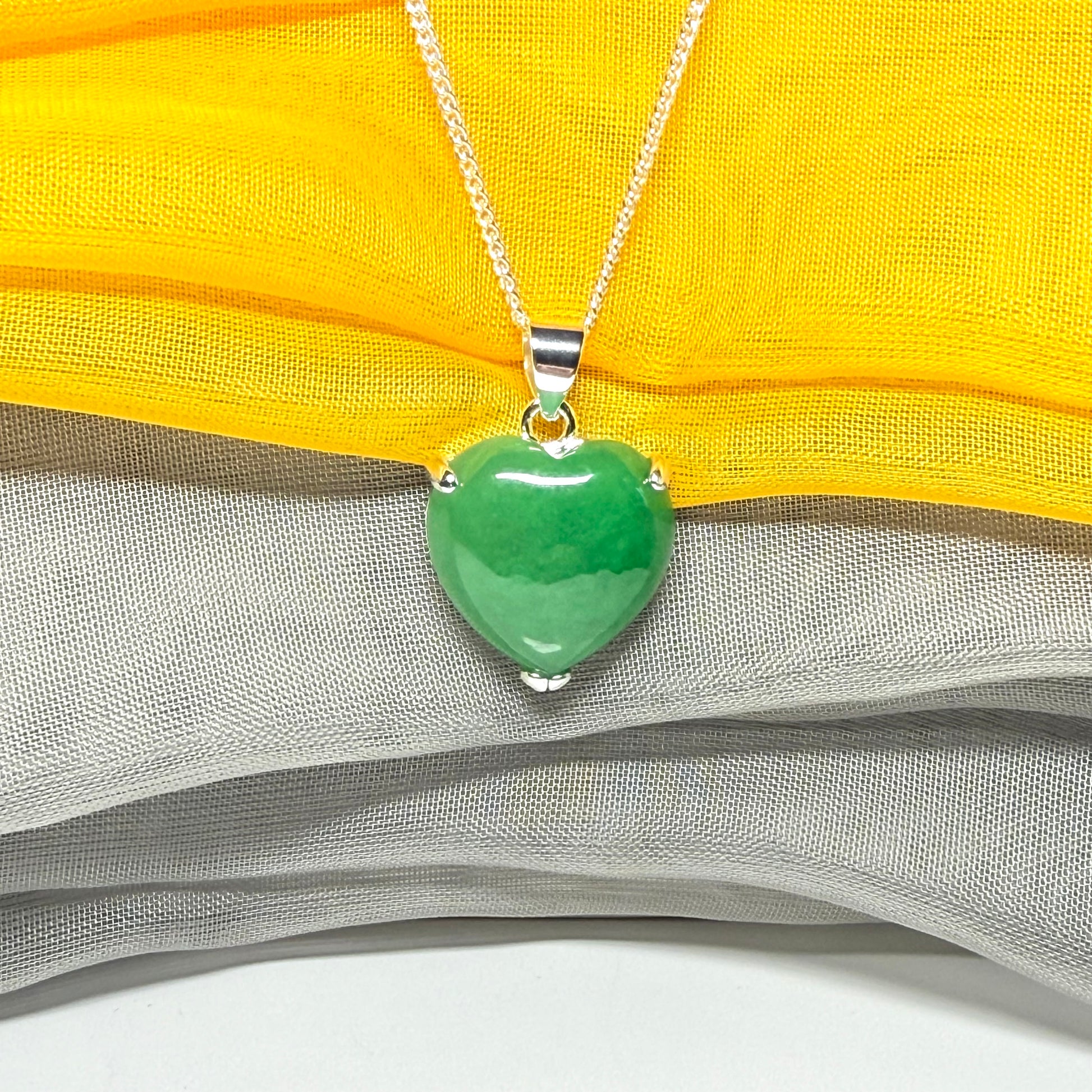 A real green jade pendant heart shaped sterling silver, a traditional design with a chain