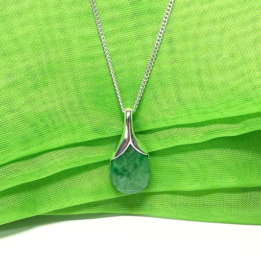Green pendant necklace on a green fabric background