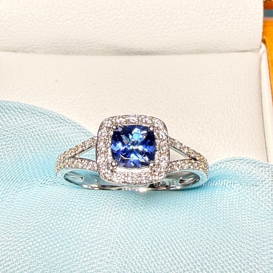 Silver ring with a blue gemstone on a light blue fabric background