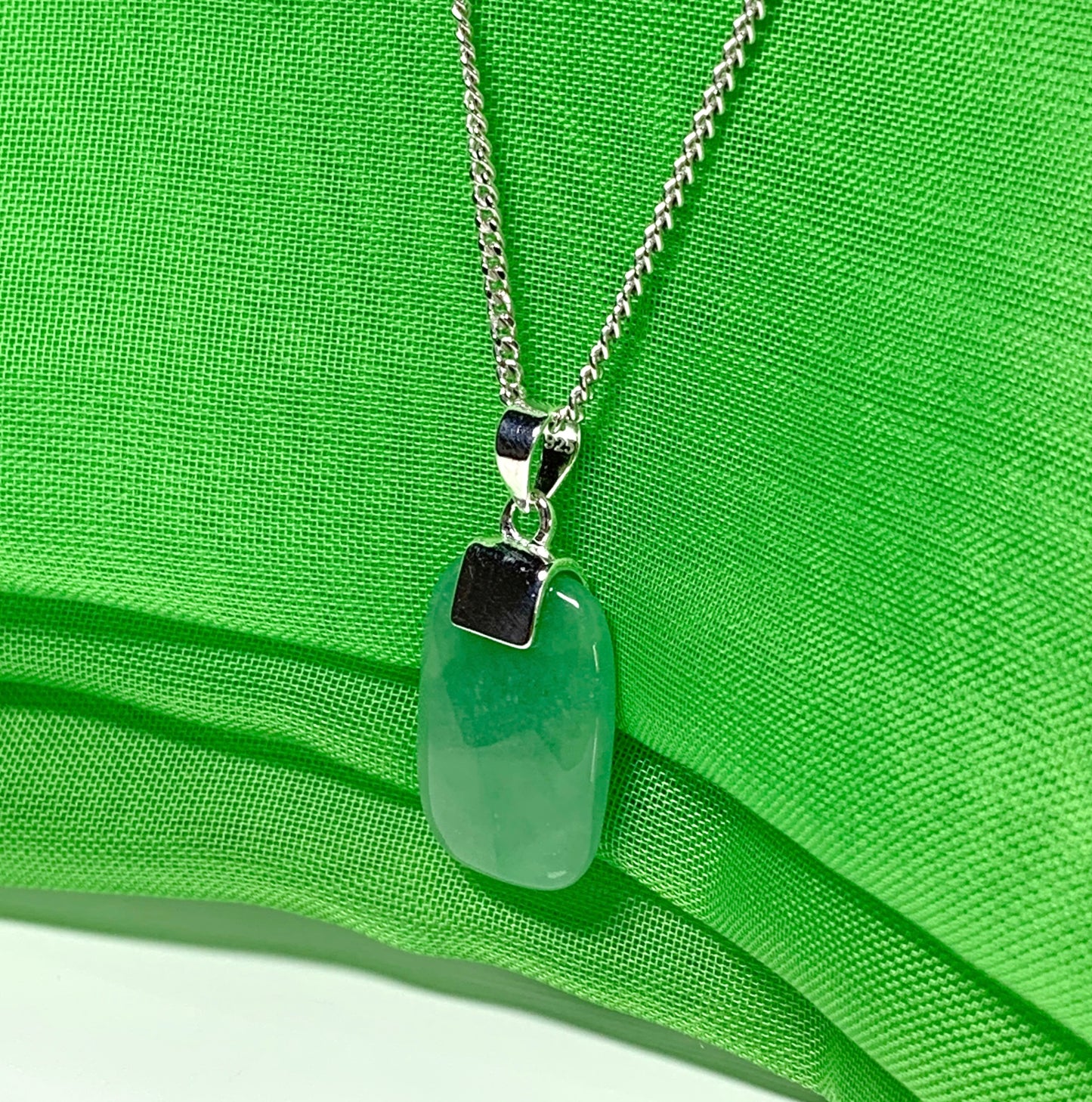 Necklace having a real green jade sterling silver cushion shaped pendant