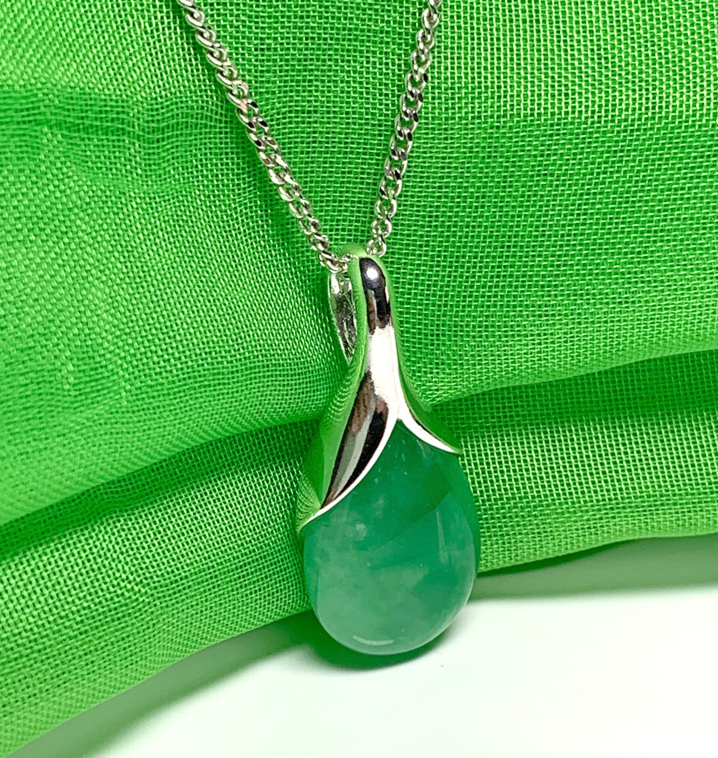 Real green jade necklace in a tear drop or pear shaped sterling silver pendant