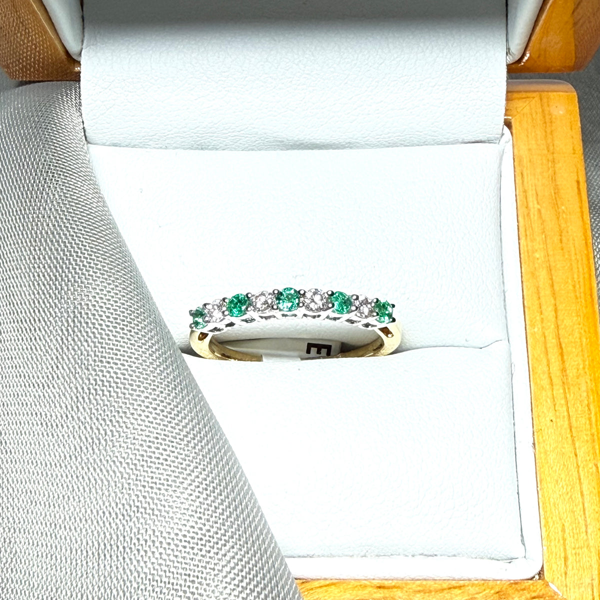 A stunning real emerald and diamond yellow gold eternity ring claw setting