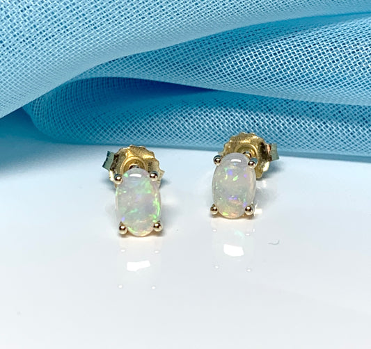 Real opal yellow gold claw set oval stud earrings