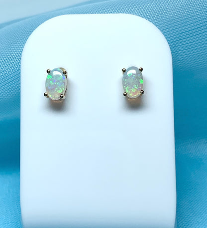 Real opal yellow gold claw set oval stud earrings