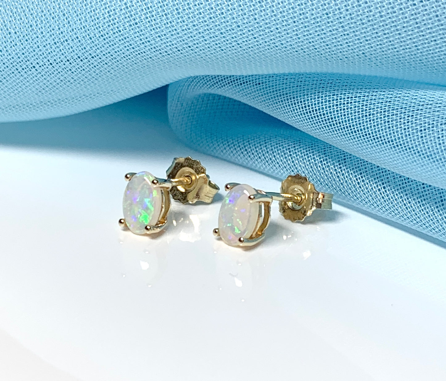 Real opal yellow gold claw set oval stud earrings