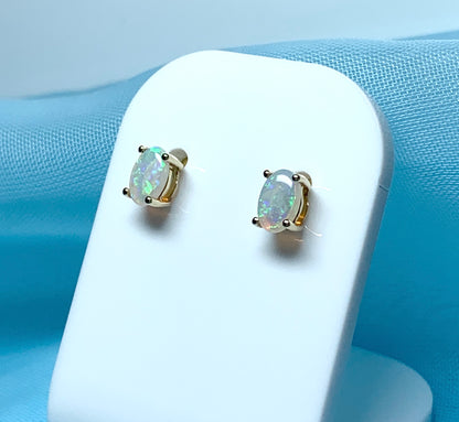 Real opal yellow gold claw set oval stud earrings