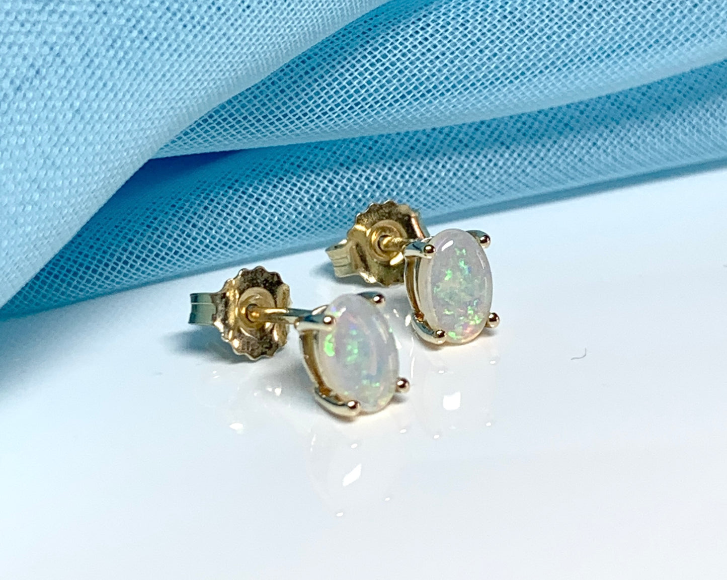 Real opal yellow gold claw set oval stud earrings