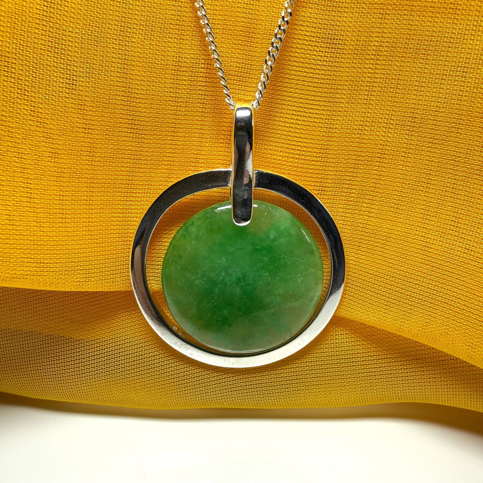 A shimmering large round halo necklace sterling silver circle shaped green real jade