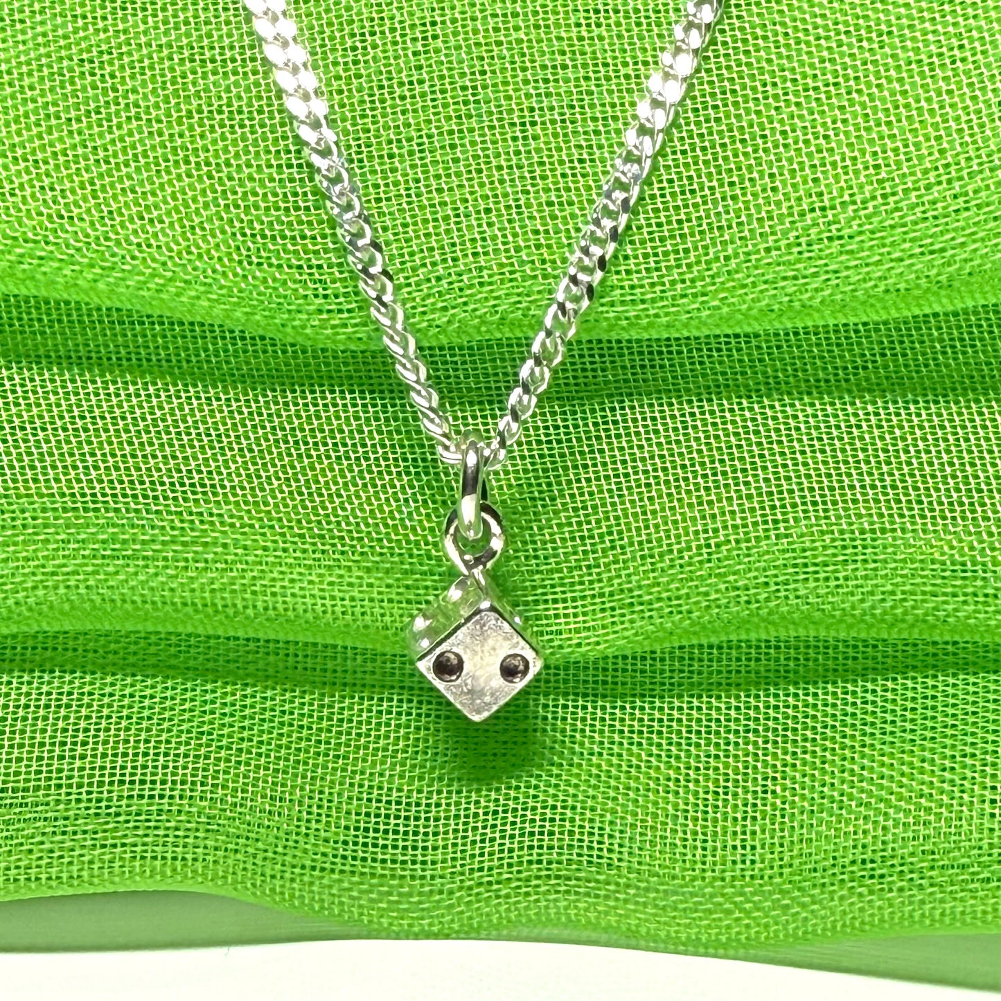 Small dice shaped sterling silver necklace with a chain included