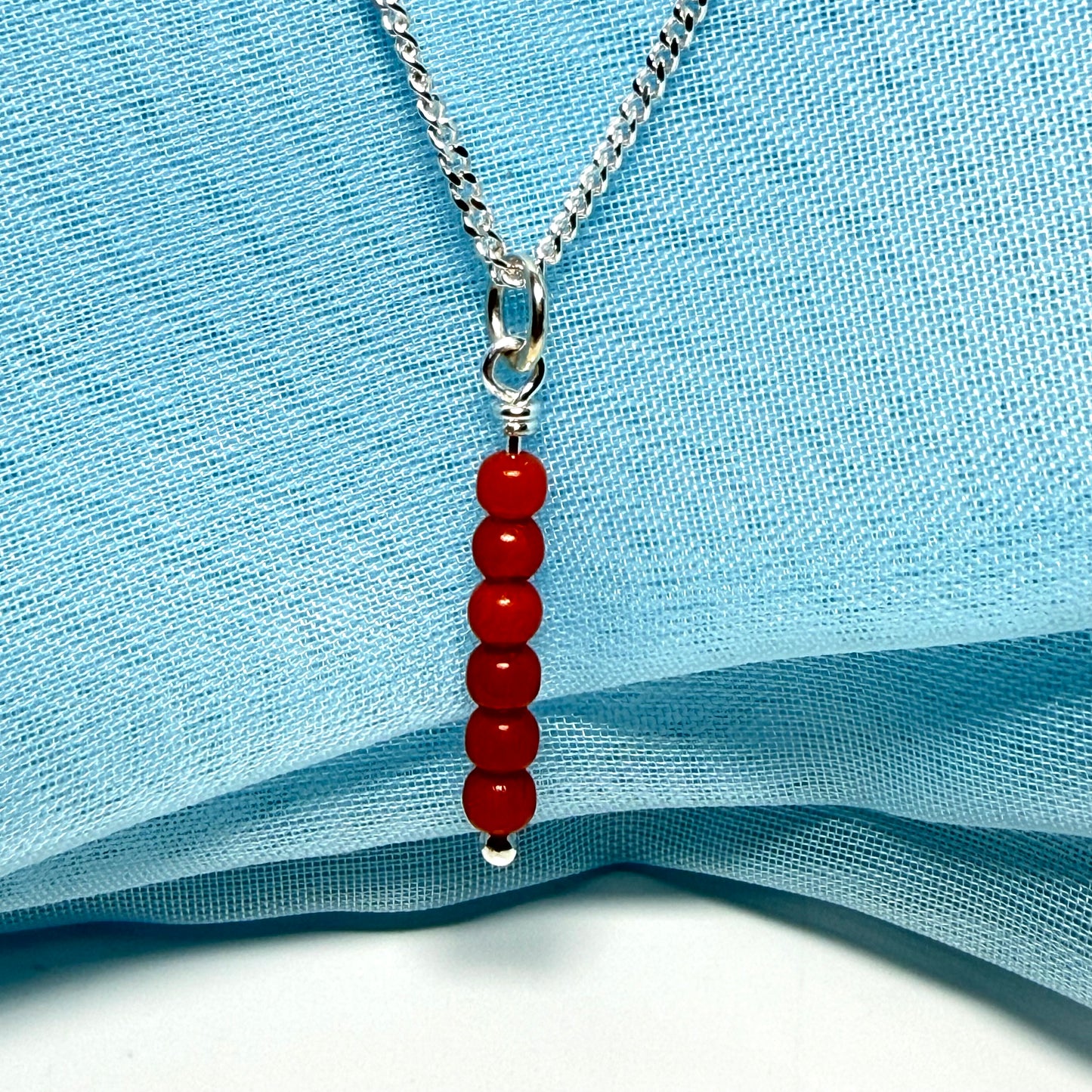 A small real coral necklace round long designed pendant with a chain included as well