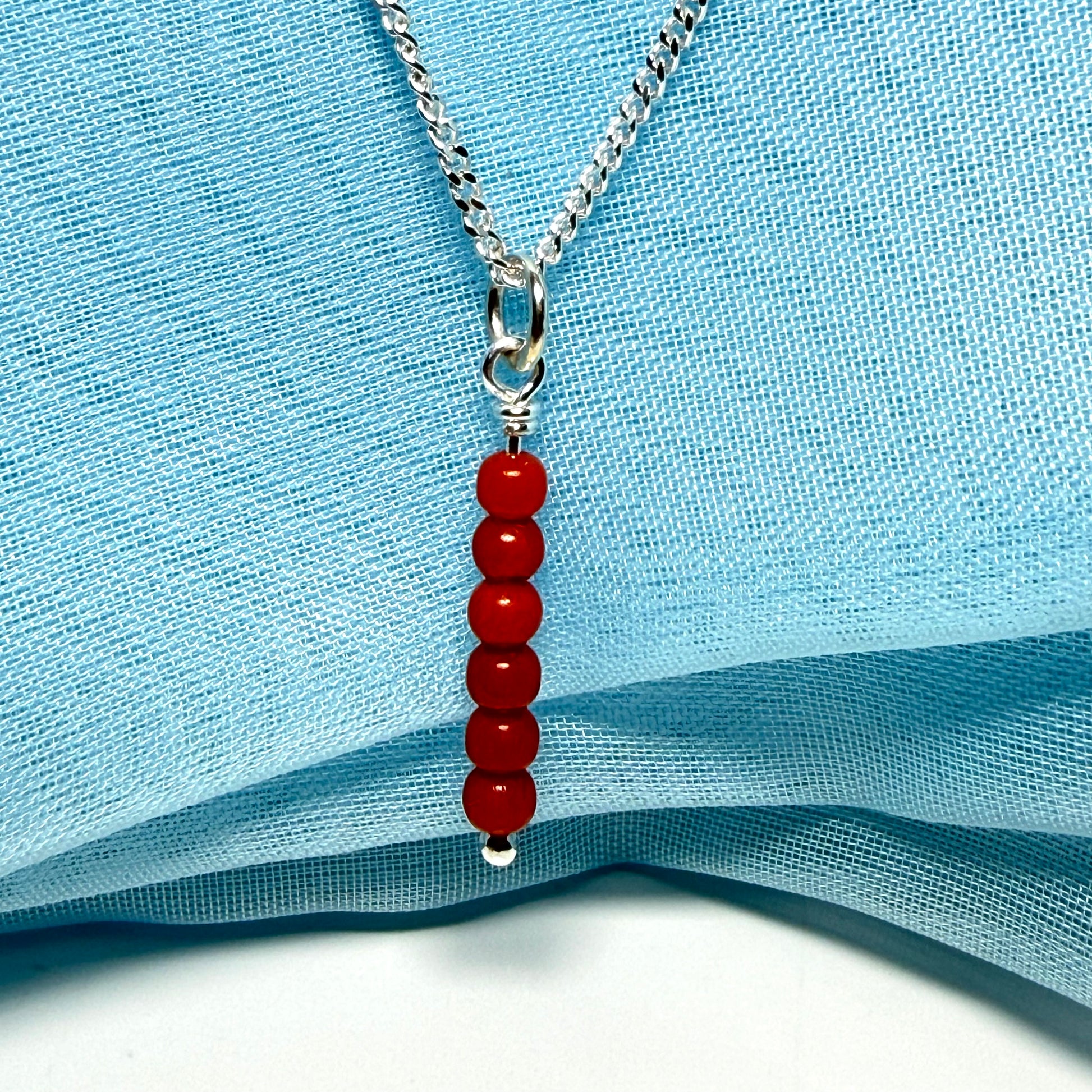 A small real coral necklace round long designed pendant with a chain included as well
