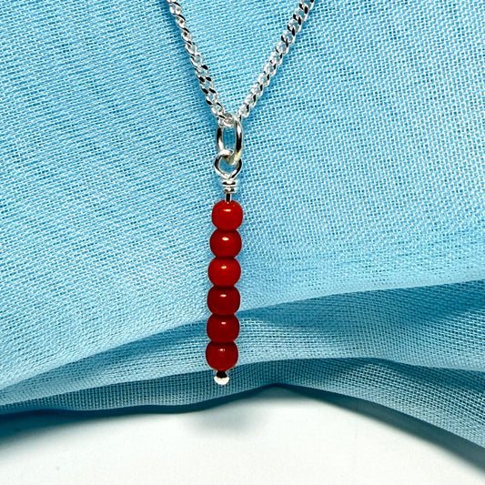 A small real coral necklace round long designed pendant with a chain included as well