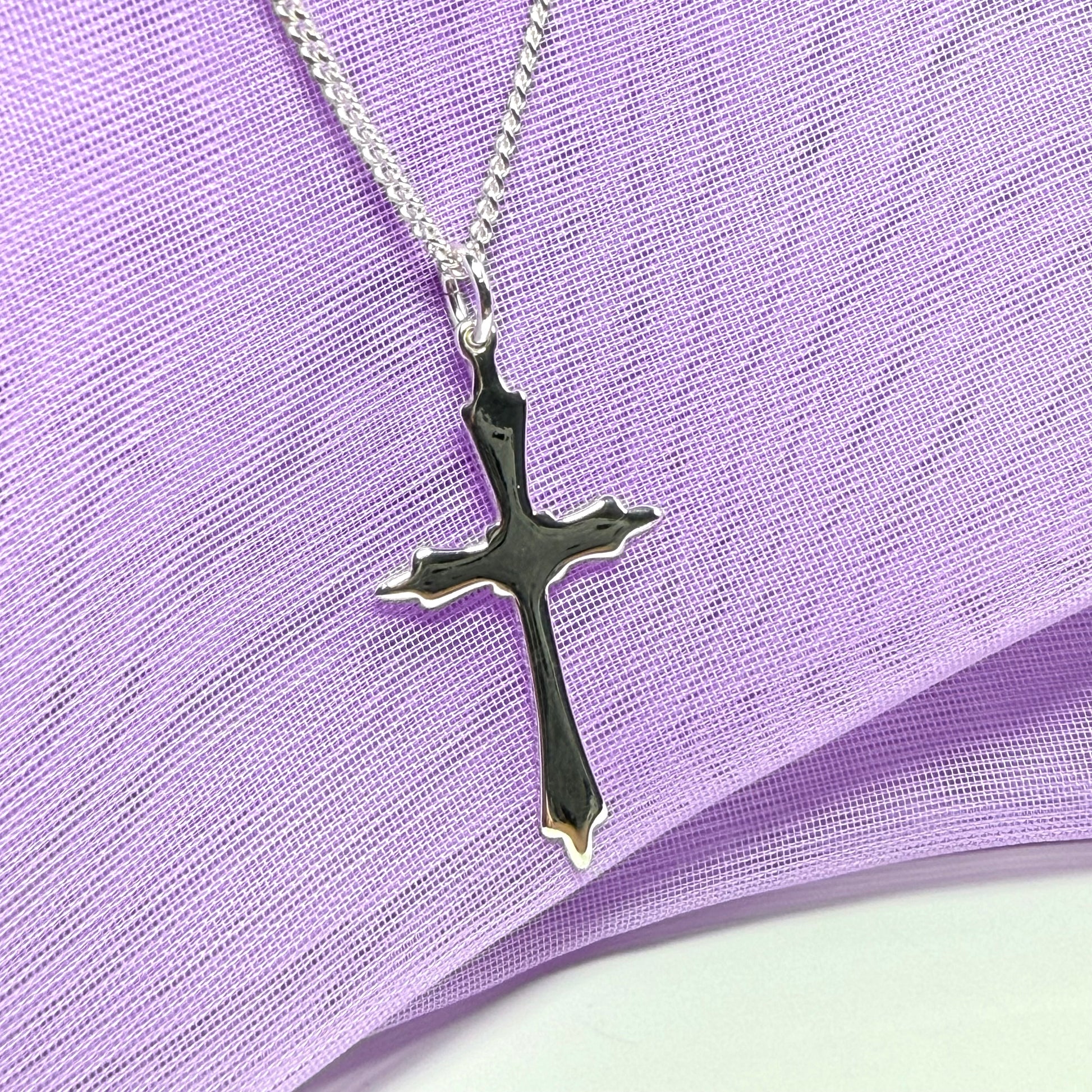 A solid fancy shaped sterling silver cross necklace pendant with a chain included