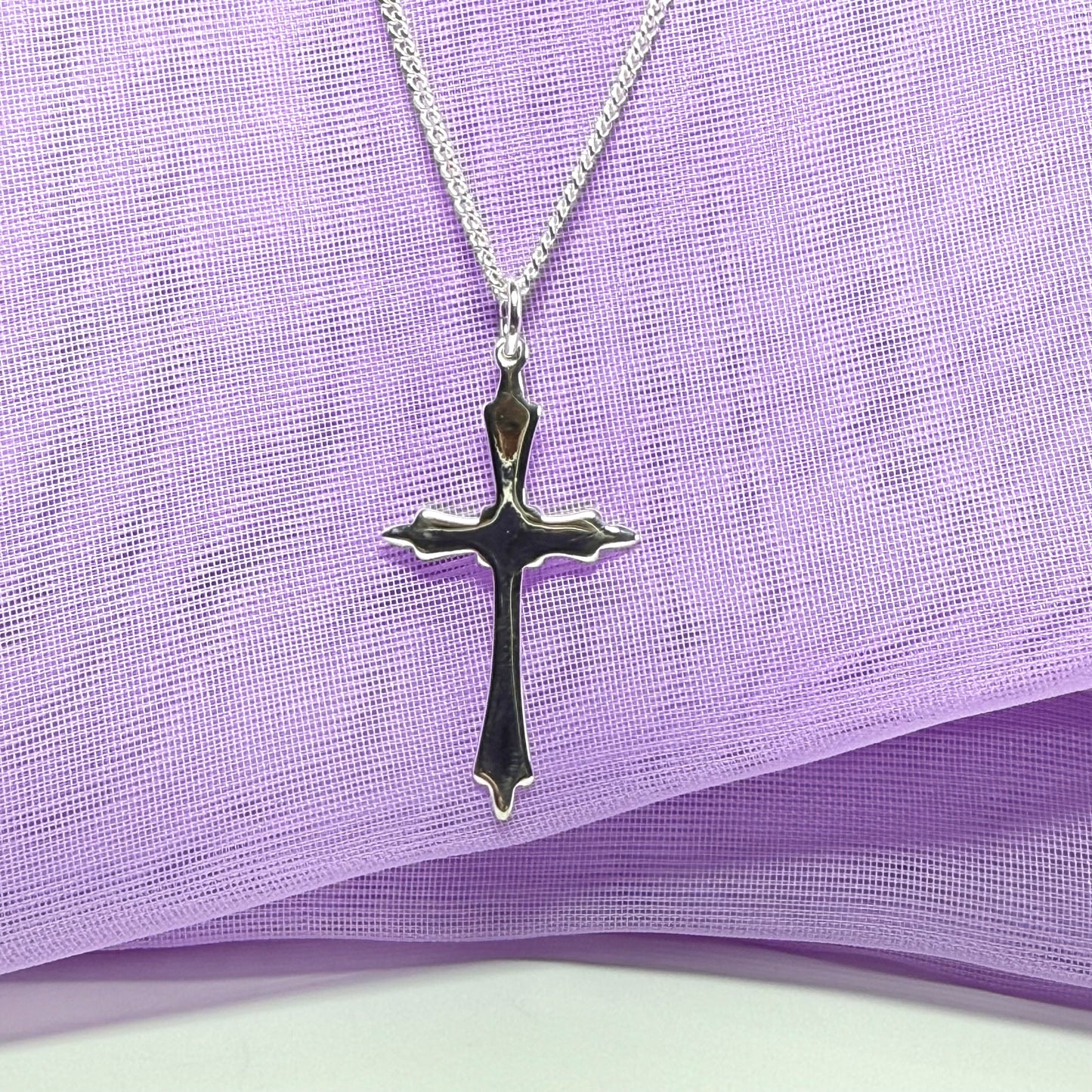 A solid fancy shaped sterling silver cross necklace pendant with a chain included