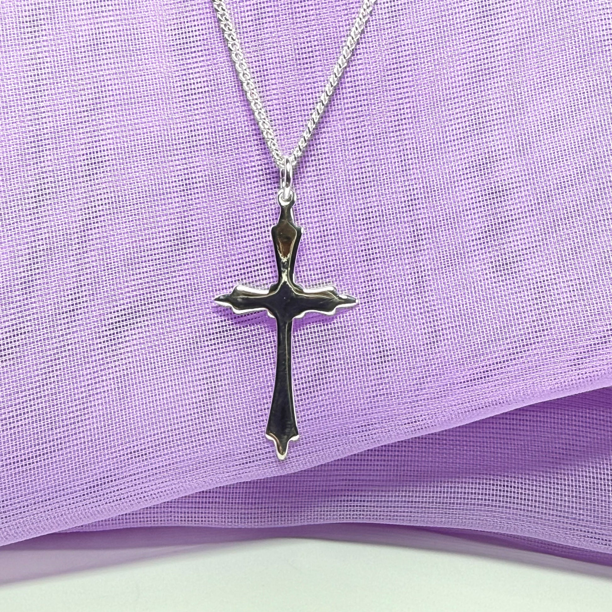 A solid fancy shaped sterling silver cross necklace pendant with a chain included