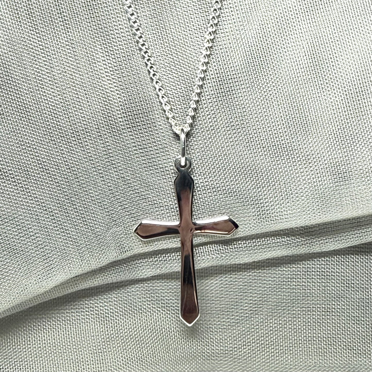 A solid sterling silver cross necklace fancy shaped pendant with a chain