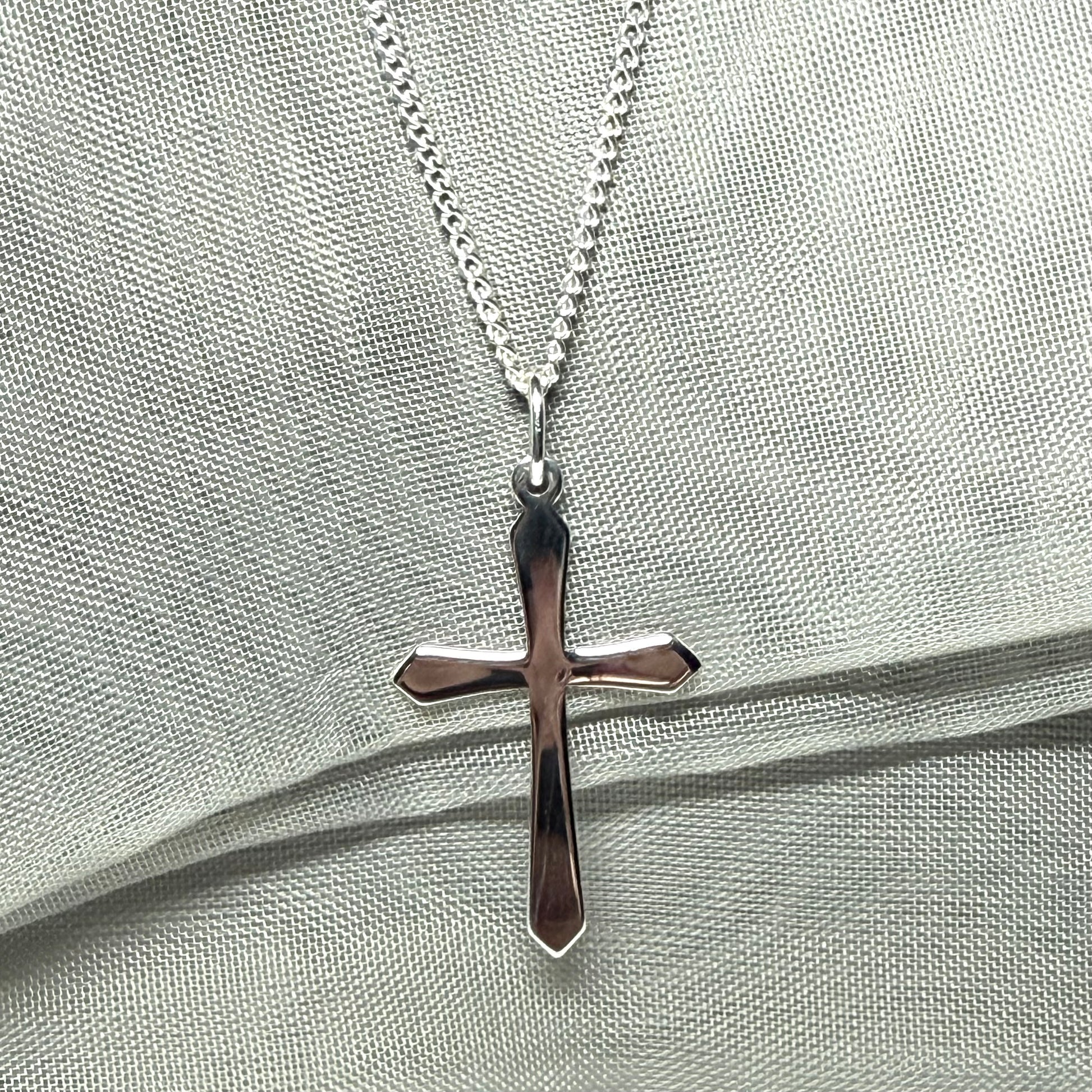 A solid sterling silver cross necklace fancy shaped pendant with a chain
