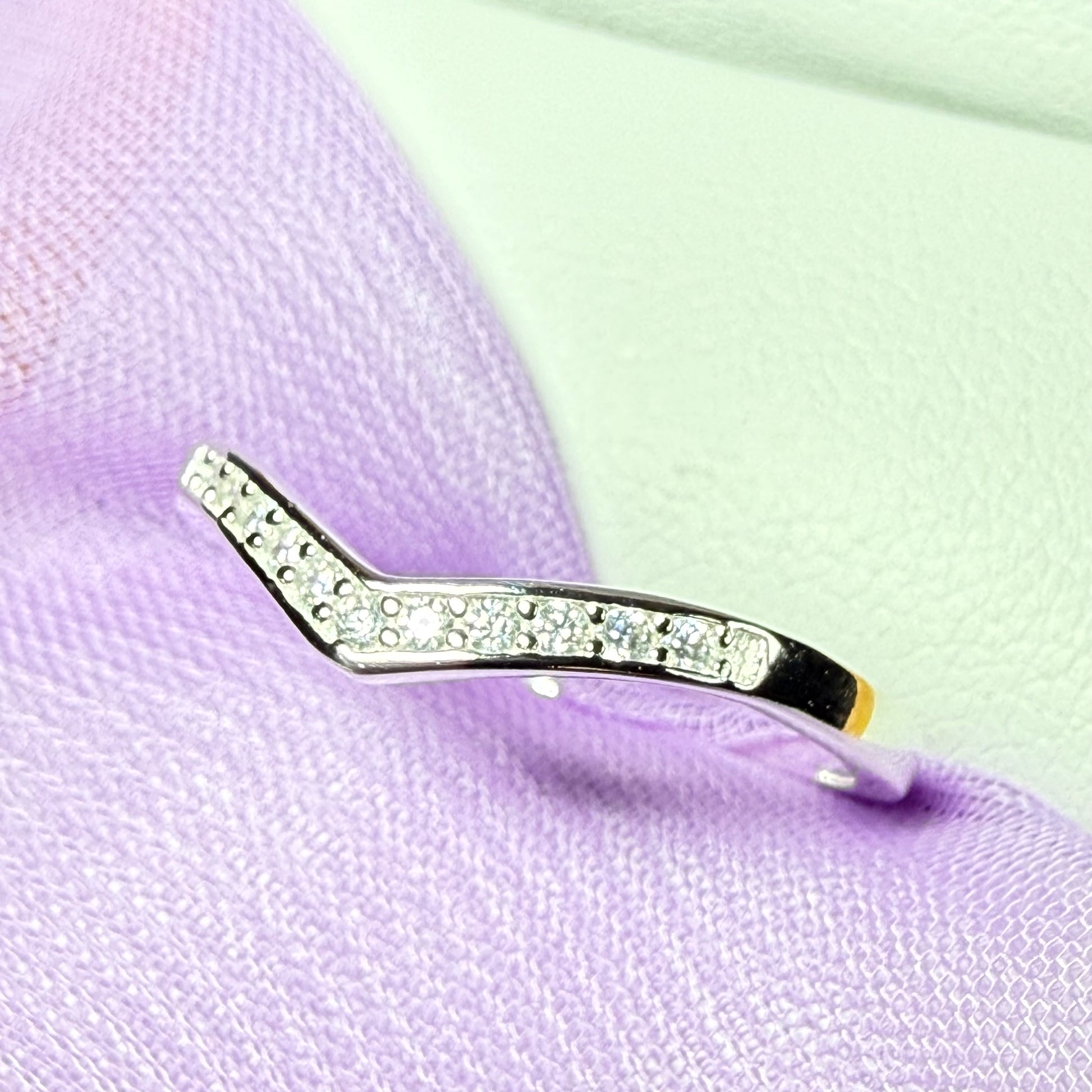 Diamond-studded earring on a purple fabric background