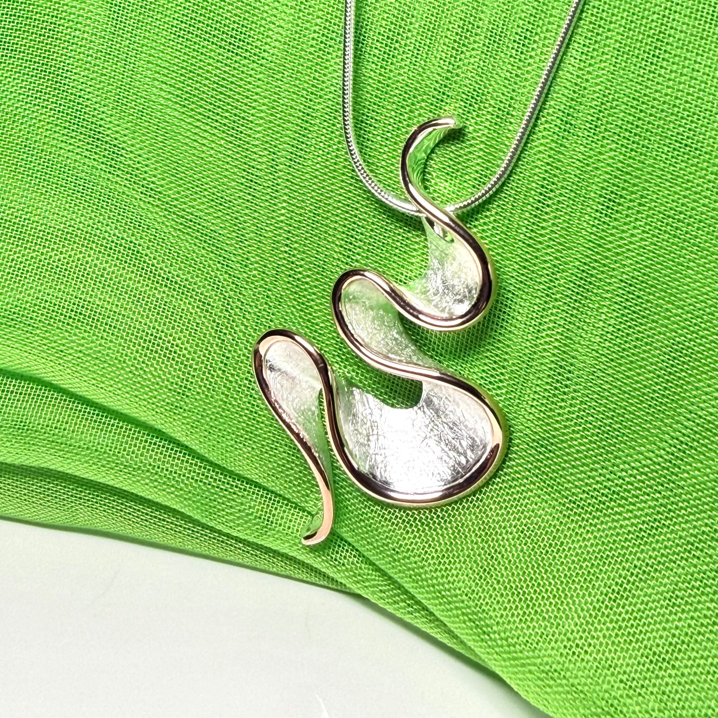 A sterling silver solid rounded open pierced fancy swirl necklace with snake chain