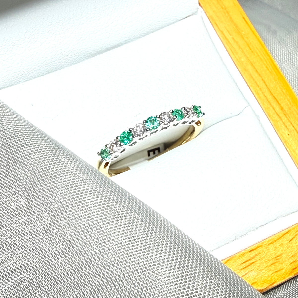 A stunning real emerald and diamond yellow gold eternity ring claw setting