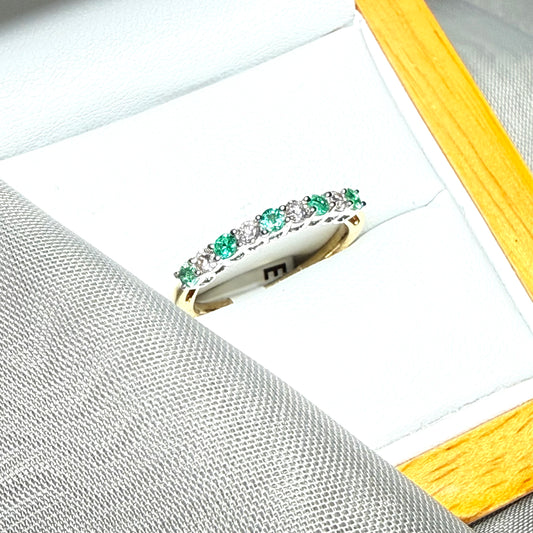 A stunning real emerald and diamond yellow gold eternity ring claw setting