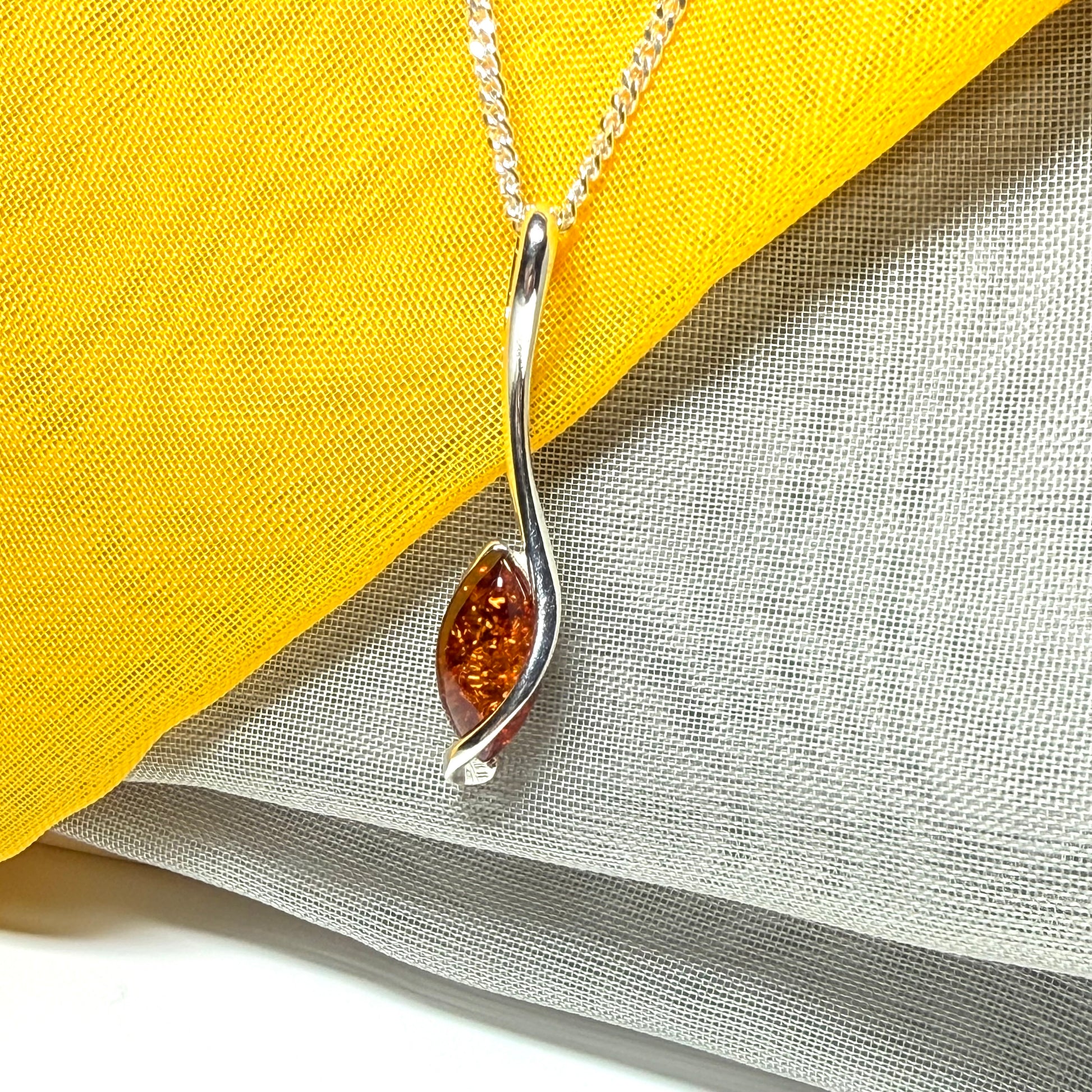 A Sterling silver real amber marquise shaped necklace swirled pendant
