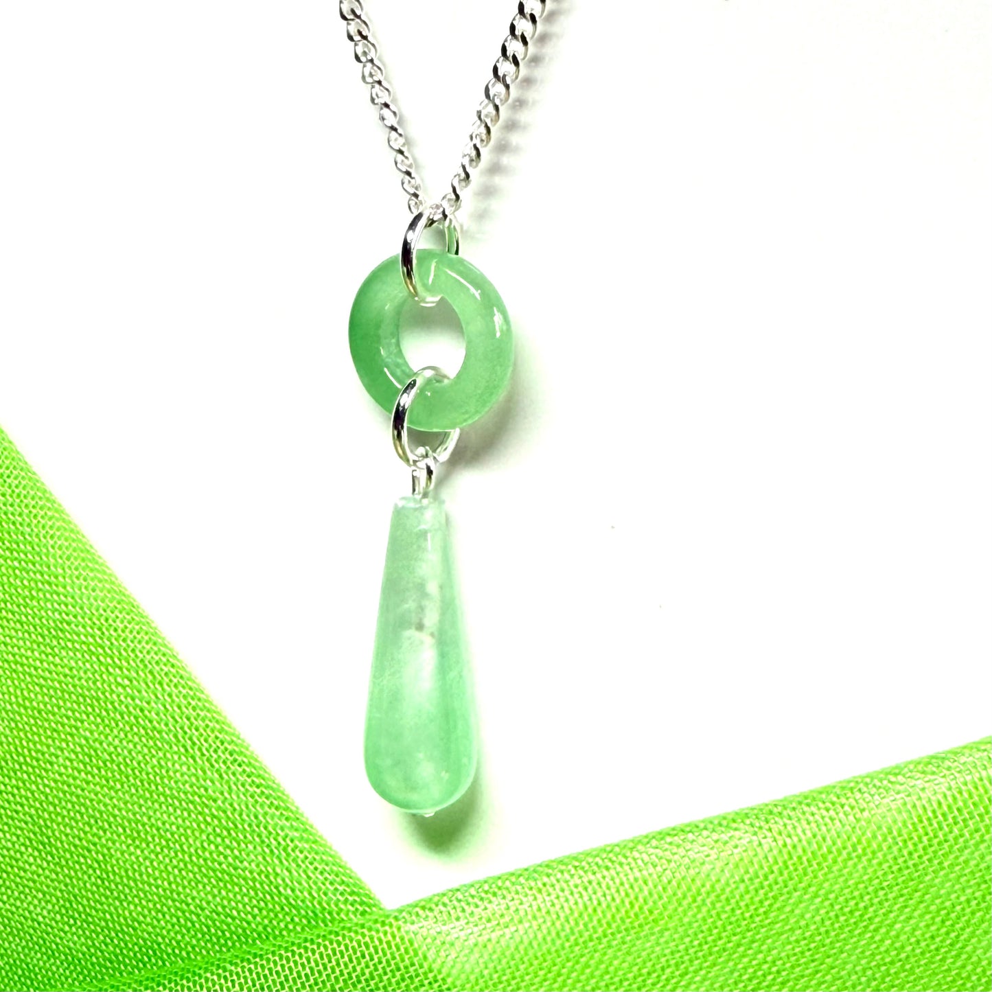 Necklace with a real green jade pendant on a white background